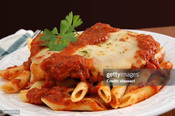 plate of chicken parmigiana on table garnished with cilantro - chicken parmigiana stockfoto's en -beelden