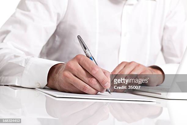 businessman holding a pen & taking notes on paper - petition stock pictures, royalty-free photos & images