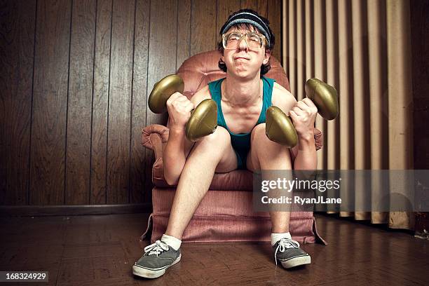 nerd young man exercising with weights - weakness man stock pictures, royalty-free photos & images