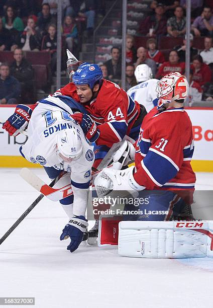 Davis Drewiske of the Montreal Canadiens body checks Steven Stamkos of the Tampa Bay Lightning during the NHL game on April 18, 2013 at the Bell...