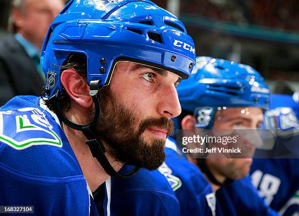 Jason Garrison of the Vancouver Canucks looks on from the bench during their NHL game against the Detroit Red Wings at Rogers Arena April 20, 2013 in...