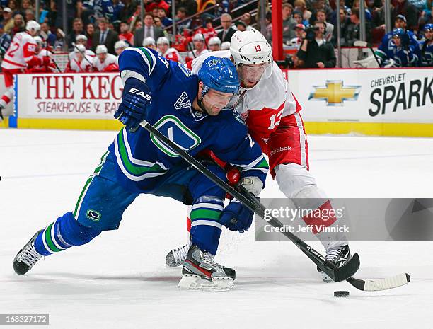 Dan Hamhuis of the Vancouver Canucks and Pavel Datsyuk of the Detroit Red Wings battle for a loose puck during their NHL game at Rogers Arena April...