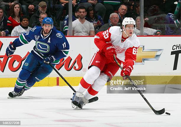Ryan Kesler of the Vancouver Canucks skates after Danny Dekeyser of the Detroit Red Wings as he skates up ice with the puck during their NHL game at...