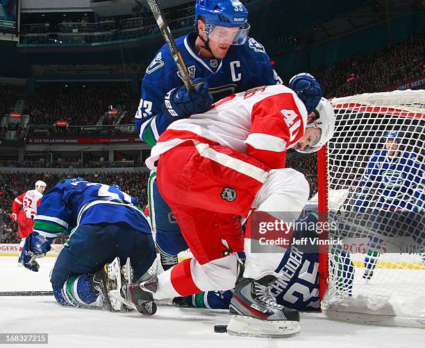 Henrik Sedin of the Vancouver Canucks checks Henrik Zetterberg of the Detroit Red Wings during their NHL game at Rogers Arena April 20, 2013 in...