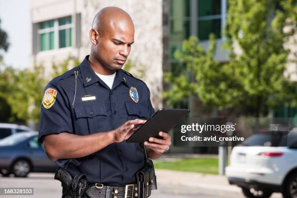 oficial de policía usando computadora tablet - cuerpo de policía fotografías e imágenes de stock