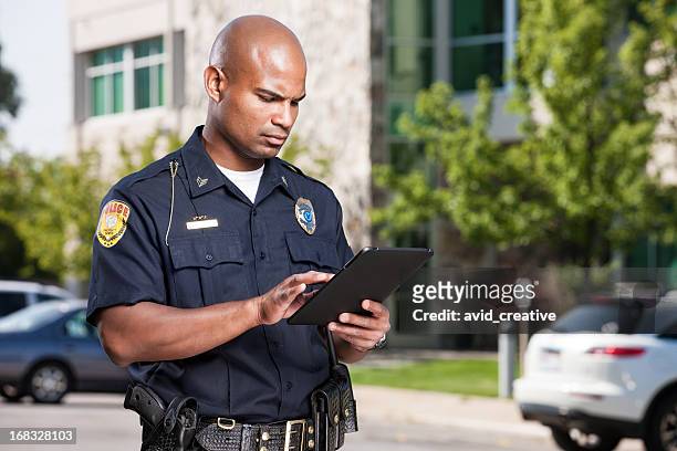 police officer using computer tablet - poliskår bildbanksfoton och bilder
