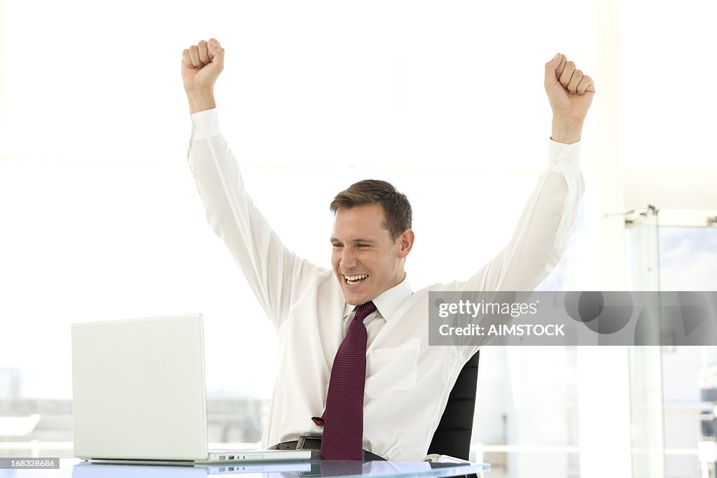 Successful young businessman using laptop