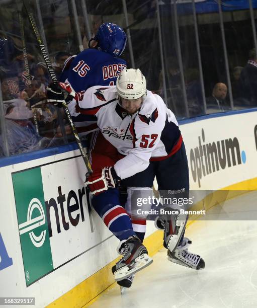 Mike Green of the Washington Capitals hits Derek Dorsett of the New York Rangers into the boards in Game Four of the Eastern Conference Quarterfinals...