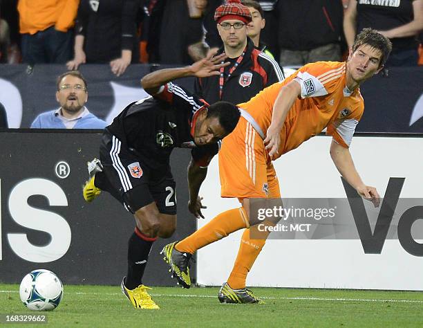 United forward Lionard Pajoy , left, tries to maintain his balance and go after the ball after getting tripped by Houston Dynamo defender Bobby...
