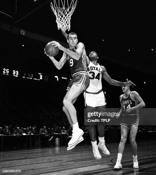 Bob Pettit of the St. Louis Hawks grabs the rebound as he boxes out Wayne Embry of the Cincinnati Royals during an NBA game at Madison Square Garden...