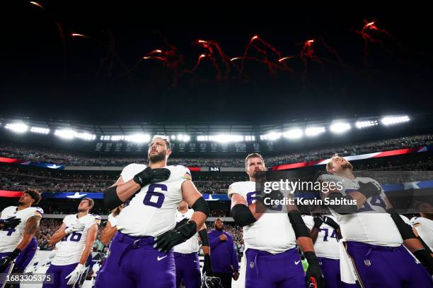 David Quessenberry and Austin Schlottmann of the Minnesota Vikings stand on the sidelines during the national anthem prior to an NFL football game...