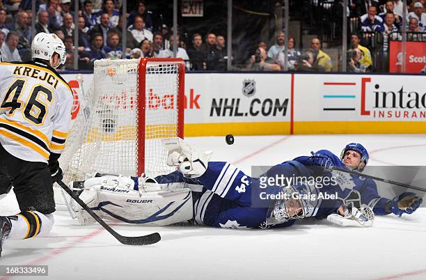 James Reimer and Dion Phaneuf of the Toronto Maple Leafs sprawl out to defend as David Krejci of the Boston Bruins shoots in Game Four of the Eastern...