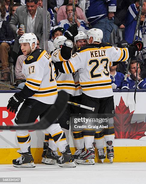 Milan Lucic, Brad Marchand, David Krejci and Chris Kelly of the Boston Bruins celebrate an overtime win in Game Four of the Eastern Conference...