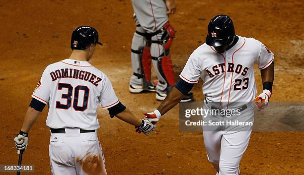 Chris Carter and Matt Dominguez of the Houston Astros celebrate after Carter hit a solo home run against the Los Angeles Angels of Anaheim in the...
