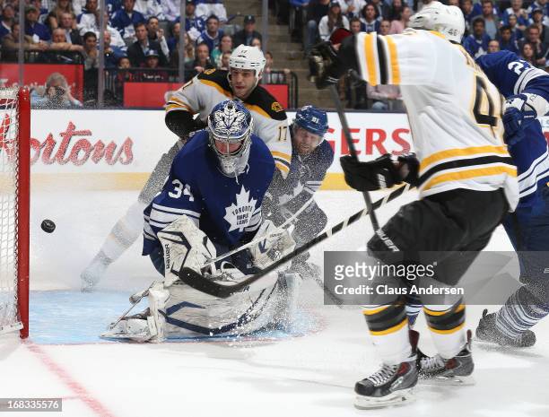 David Krejci of the Boston Bruins scores the overtime winning goal against James Reimer of the Toronto Maple Leafs in Game Four of the Eastern...