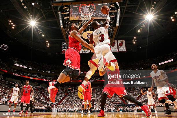 Dwyane Wade of the Miami Heat shoots a reverse layup against Daequan Cook of the Chicago Bulls in Game Two of the Eastern Conference Semifinals...