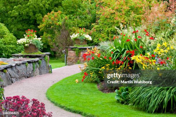 flowerbeds, flowerpots and stone wall - landscaped walkway stock pictures, royalty-free photos & images
