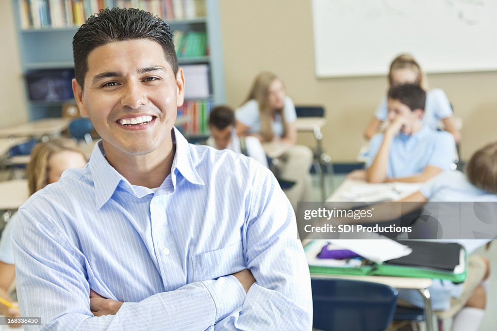 Smiling teacher in his classroom full of students