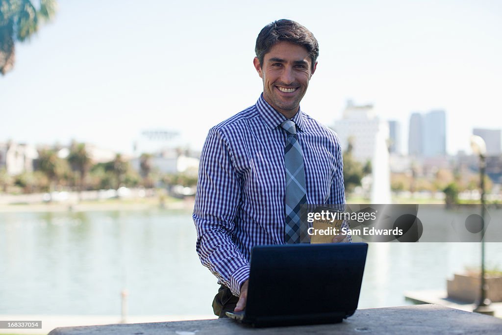 Businessman working on laptop in park