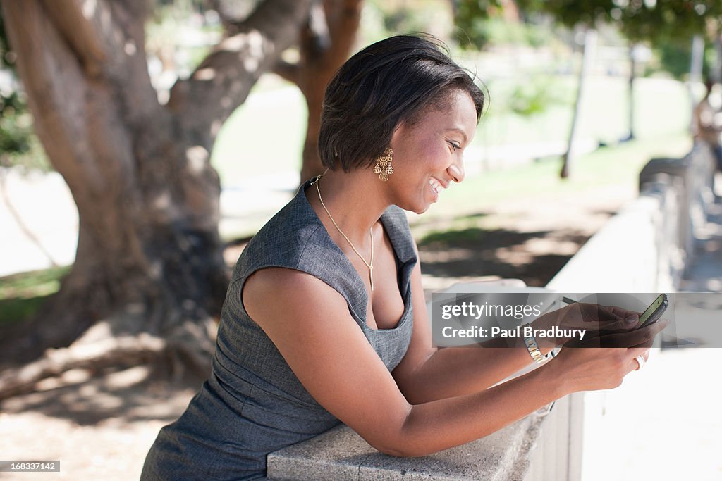 Businesswoman using cell phone outdoors