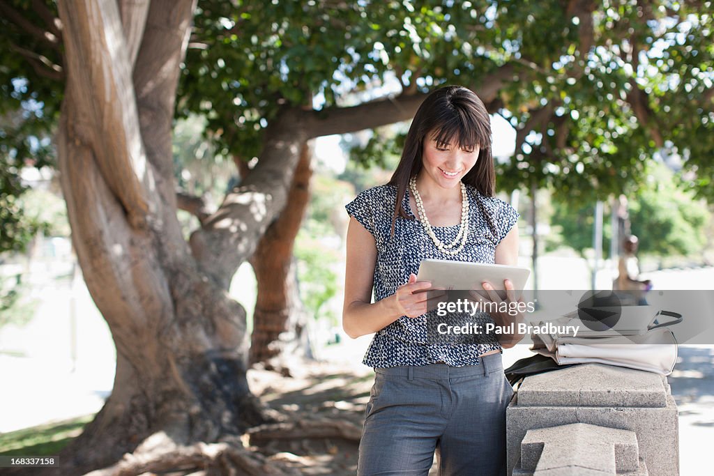 Businesswoman using tablet computer outdoors