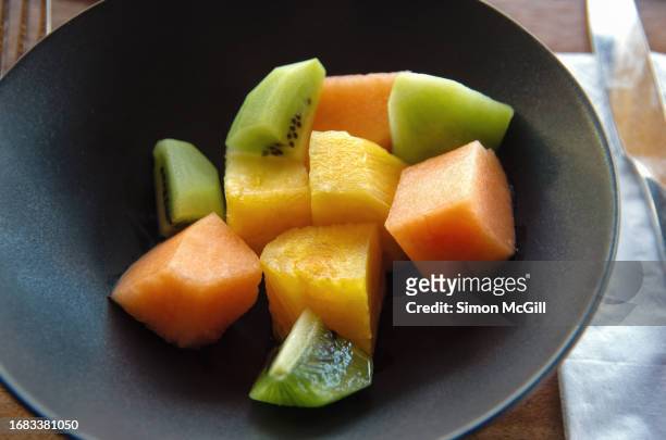 cut fresh fruit bowl of kiwi fruit, rock-melon and pineapple chunks - rockmelon stock pictures, royalty-free photos & images