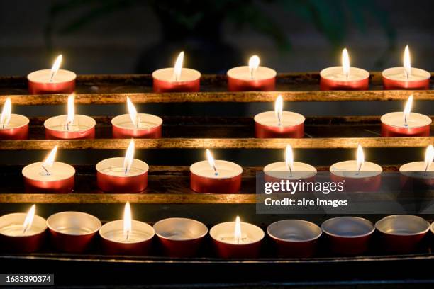 close-up of a group of lighted candles in red glasses, no people around, front view - chapel service stock pictures, royalty-free photos & images