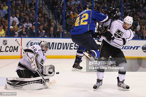David Backes of the St. Louis Blues jumps out of the way of a shot on goal against Drew Doughty of the Los Angeles Kings as Jonathan Quick of the Los...