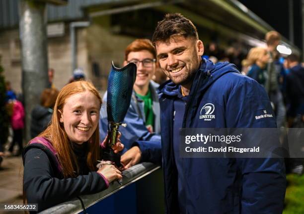 Meath , Ireland - 22 September 2023; Harry Byrne of Leinster signs prosthetic leg for Leinster supporter Aoife O'Hagan after the pre season friendly...