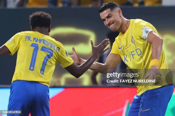 Nassr's Portuguese forward Cristiano Ronaldo celebrates scoring with Nassr's Saudi midfielder Abdullah al-Khaibari during the Saudi Pro League...