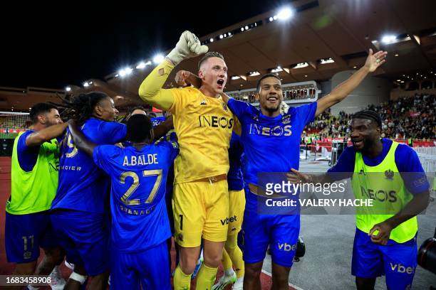 Nice's Polish goalkeeper Marcin Bulka celebrates with teammates after winning the French L1 football match between AS Monaco and OGC Nice at the...