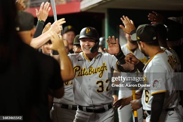 Henry Davis of the Pittsburgh Pirates hi-fives teammates in the dugout after hitting a home run in the fifth inning during the game between the...