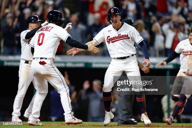 Andres Gimenez and Will Brennan of the Cleveland Guardians celebrate after scoring on a game-winning double by David Fry off Yennier Cano of the...