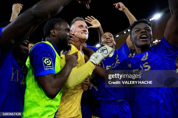 Nice's Polish goalkeeper Marcin Bulka celebrates with teammates after winning the French L1 football match between AS Monaco and OGC Nice at the...