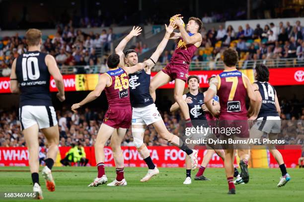 Josh Dunkley of the Lions marks the ball over Marc Pittonet of the Blues during the 2023 AFL Second Preliminary Final match between the Brisbane...