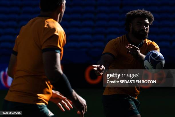 Australia's wing Marika Koroibete passes the ball to Australia's lock Richie Arnold during the captain's run training session at OL Stadium in...