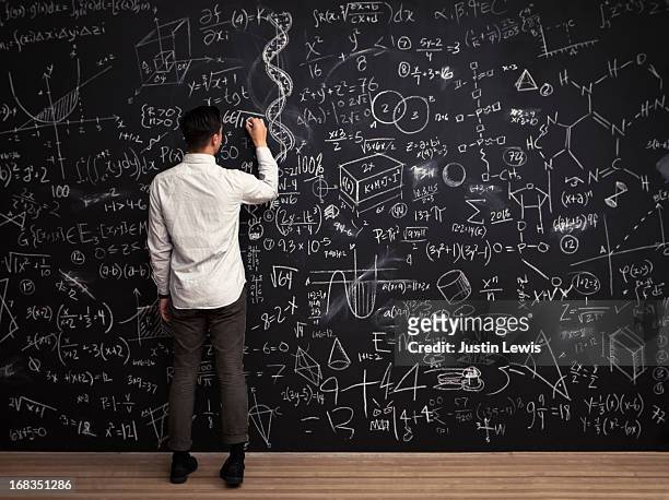 man writes mathematical equations on chalkboard - intelligent imagens e fotografias de stock