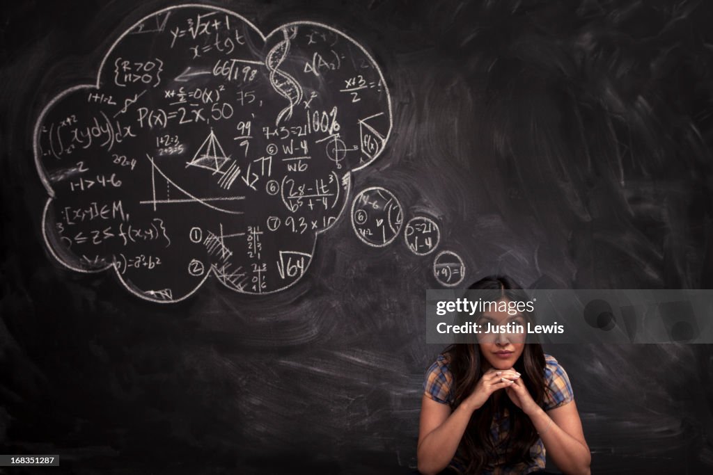 Girl contemplates math thought bubble on chalkboar