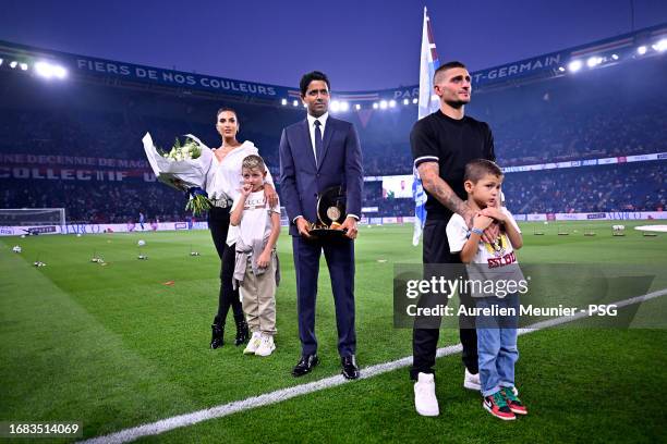 Marco Verratti stands on the pitch next to Paris Saint-Germain President Nasser Al Khelaifi, his wife Jessica Aidi and his children during his...