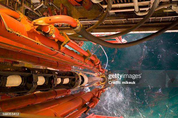 impianto di perforazione petrolifera vista riser condotte a livello del mare - industria petrolchimica foto e immagini stock