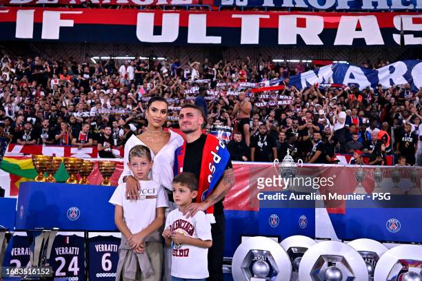 Marco Verratti poses with his wife Jessica Aidi and his children next to all the trophies he won with Paris Saint-Germain during his farewell...