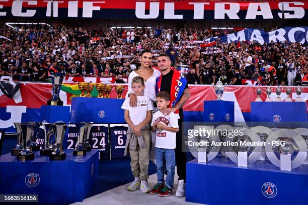 Marco Verratti poses with his wife Jessica Aidi and his children next to all the trophies he won with Paris Saint-Germain during his farewell...