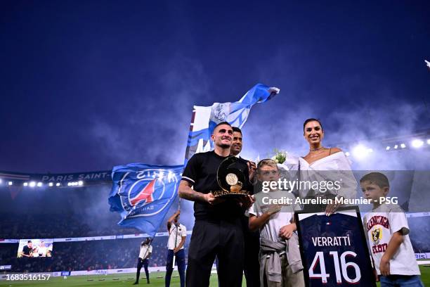 Marco Verratti stands on the pitch next to Paris Saint-Germain President Nasser Al Khelaifi, his wife Jessica Aidi and his children during his...