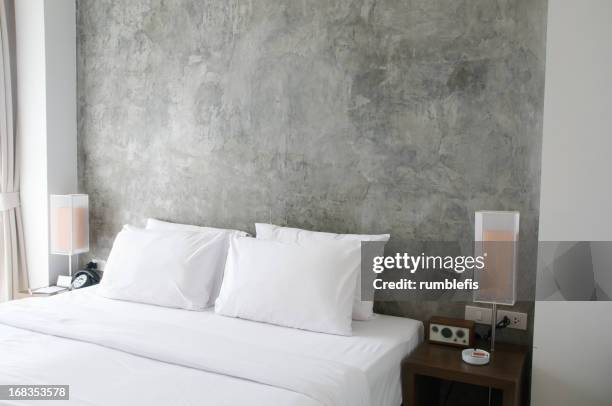 tidy bed with bedside lamps - kussen beddengoed stockfoto's en -beelden