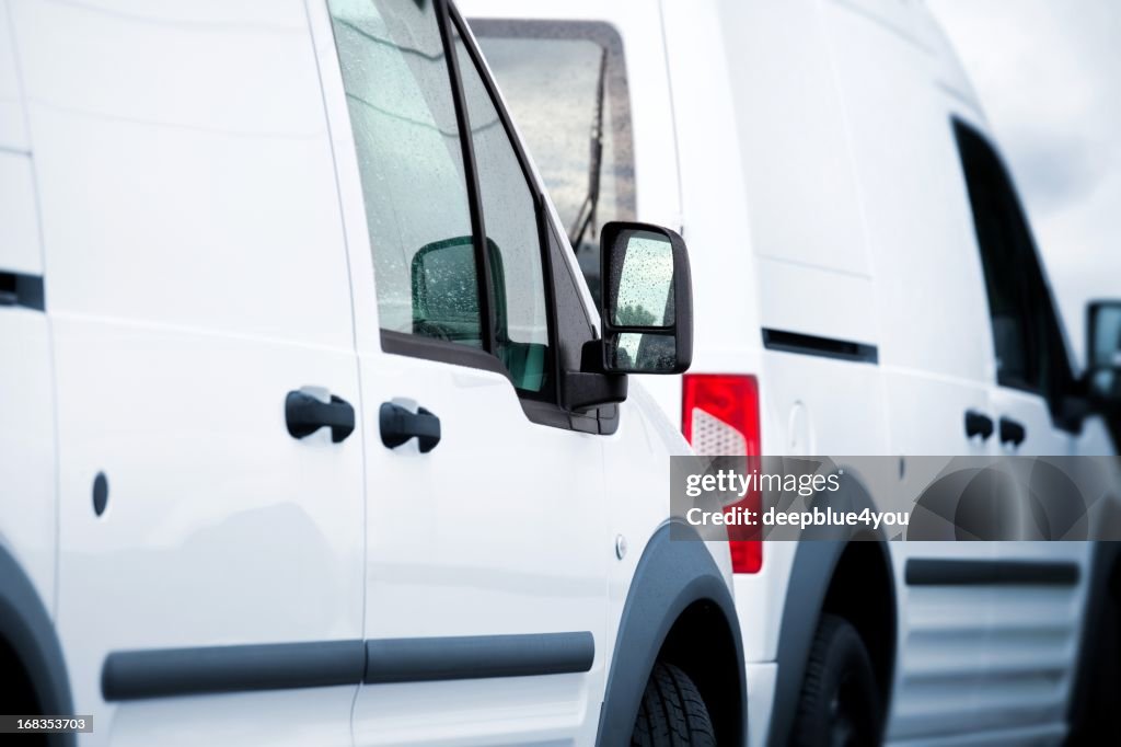 Two white vans in a parking lot