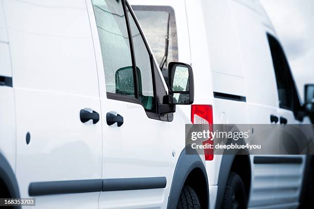 two white vans in a parking lot - mini van stock pictures, royalty-free photos & images