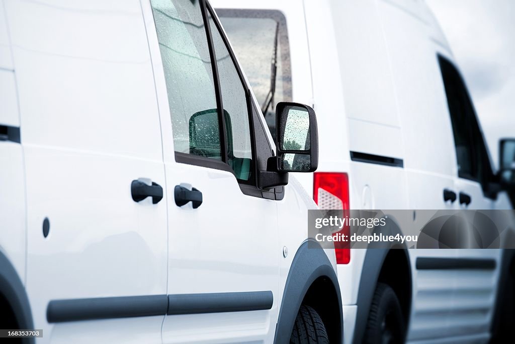 Two white vans in a parking lot