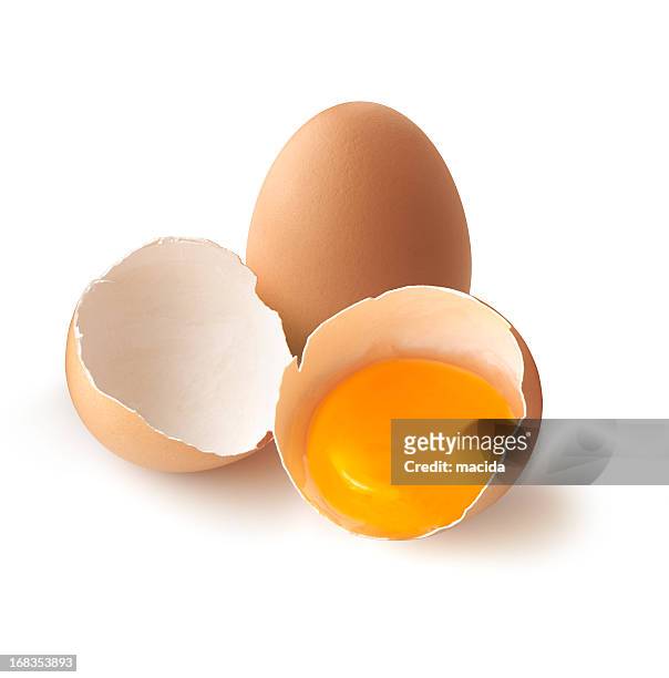 a cracked, brown egg next to a whole one - animal egg stock pictures, royalty-free photos & images