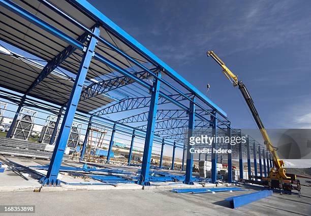 a crane working on a factory building - built structure stock pictures, royalty-free photos & images