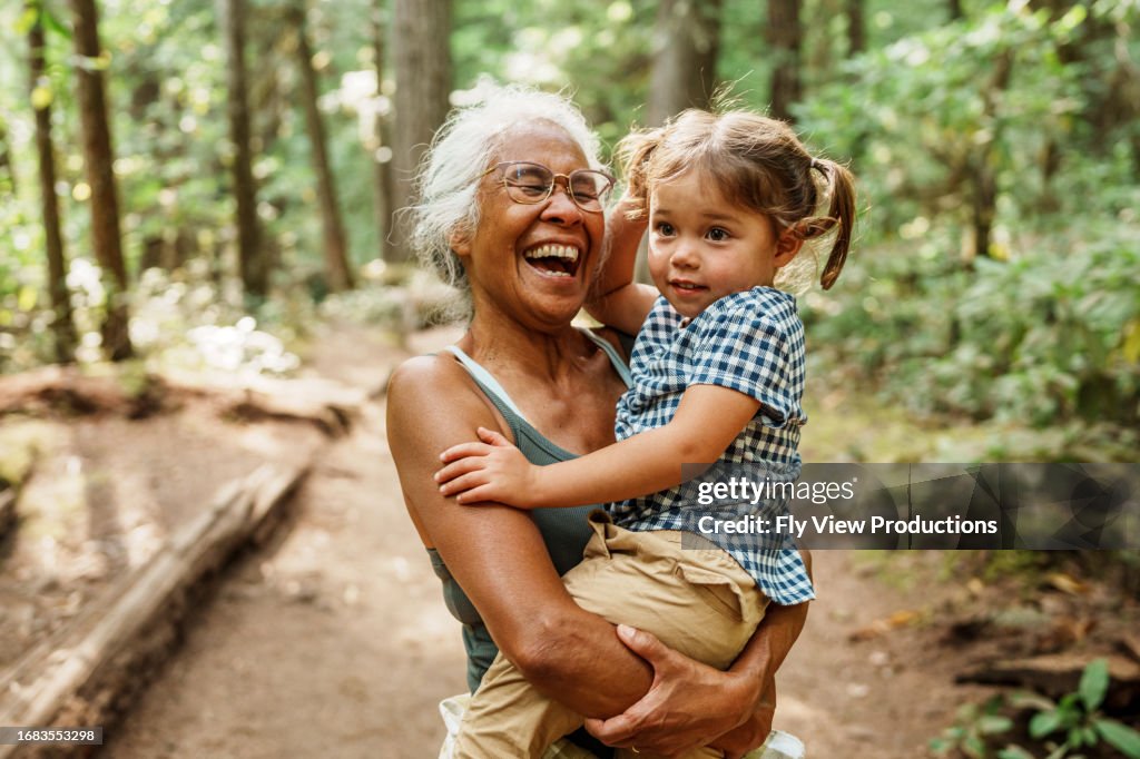 Vibrant Pacific Islander senior woman hiking with Eurasian granddaughter